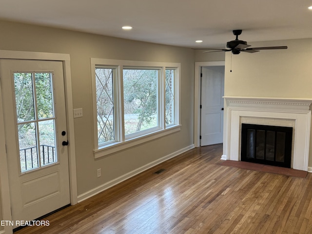 unfurnished living room with a wealth of natural light and hardwood / wood-style floors