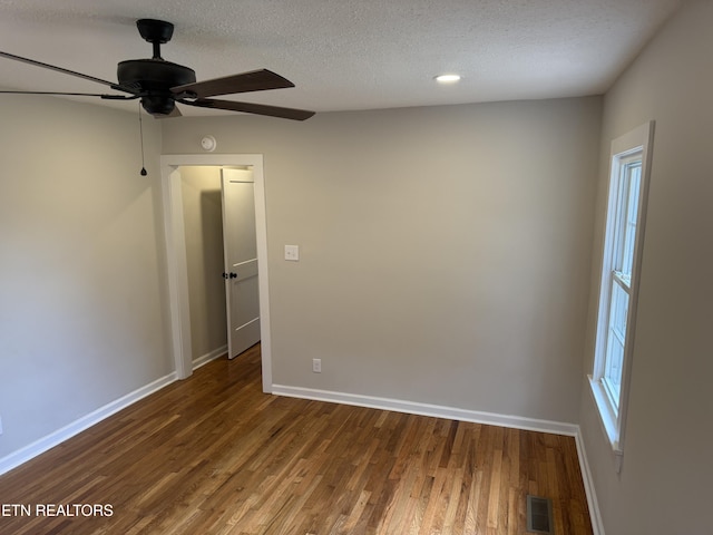 unfurnished room featuring ceiling fan, wood-type flooring, and a textured ceiling