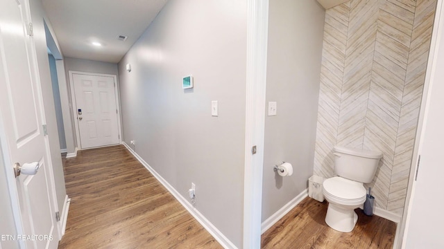 interior space with wood-type flooring and toilet