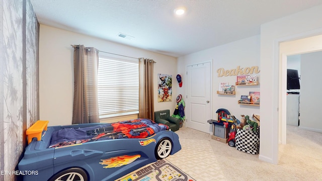 bedroom featuring carpet and a textured ceiling