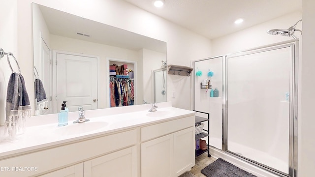 bathroom with vanity and a shower with door