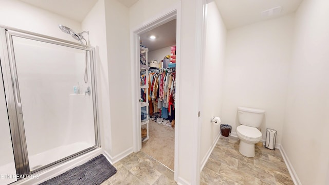 bathroom with toilet and an enclosed shower