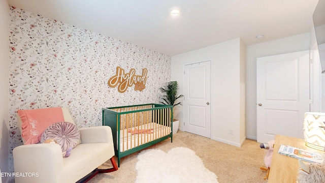 bedroom with a crib and carpet flooring