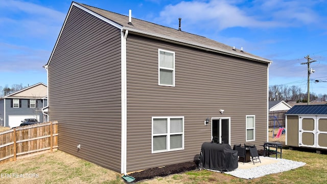 rear view of property with a patio and a storage shed