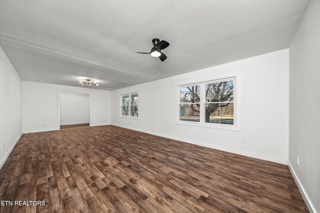 spare room featuring a textured ceiling, dark wood-type flooring, and ceiling fan