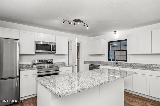 kitchen featuring sink, white cabinetry, a center island, dark hardwood / wood-style floors, and stainless steel appliances