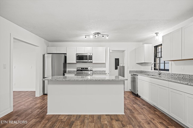 kitchen featuring appliances with stainless steel finishes, a kitchen island, and white cabinets