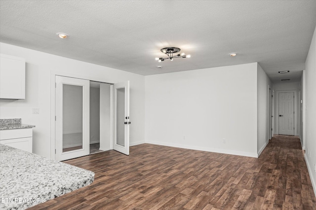 interior space with a closet, dark hardwood / wood-style flooring, and a textured ceiling