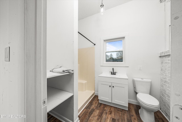 bathroom featuring hardwood / wood-style flooring, vanity, toilet, and a shower