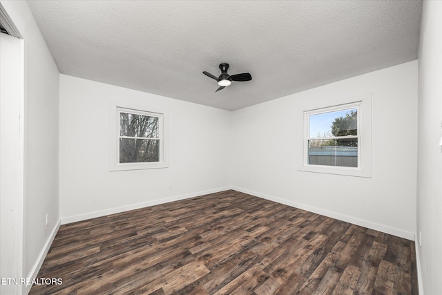 unfurnished room featuring dark wood-type flooring, ceiling fan, and a textured ceiling