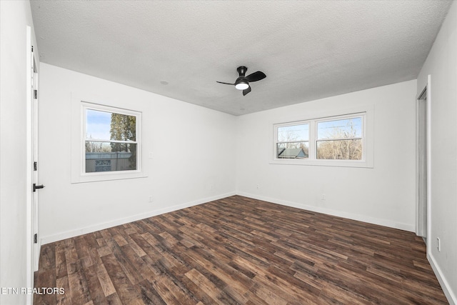 spare room with ceiling fan, plenty of natural light, and dark hardwood / wood-style floors