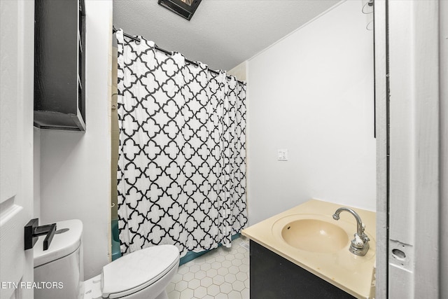 bathroom with vanity, tile patterned flooring, a textured ceiling, and toilet