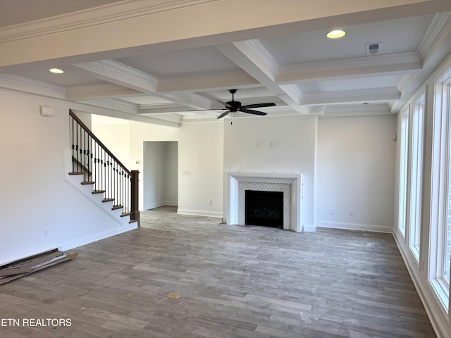 unfurnished living room with visible vents, beam ceiling, wood finished floors, stairway, and a fireplace