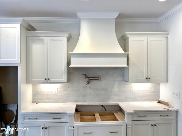 kitchen featuring backsplash, custom exhaust hood, light countertops, and white cabinetry