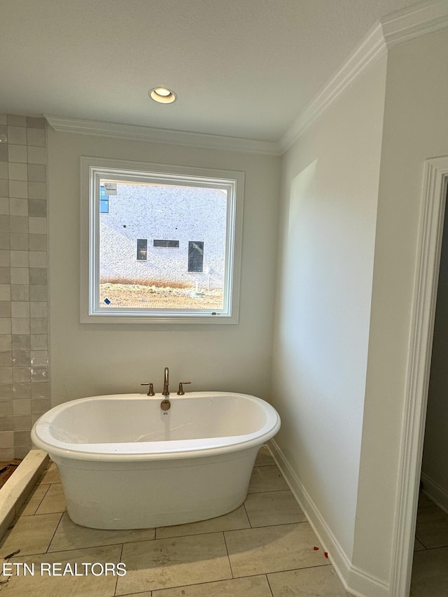 full bathroom featuring crown molding, baseboards, and a freestanding tub