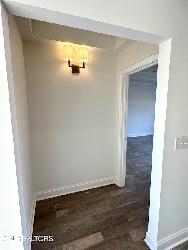 hall featuring baseboards and dark wood-type flooring