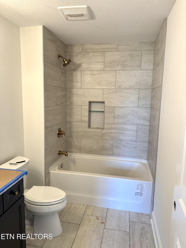 full bathroom with visible vents, toilet, a textured ceiling, shower / washtub combination, and vanity