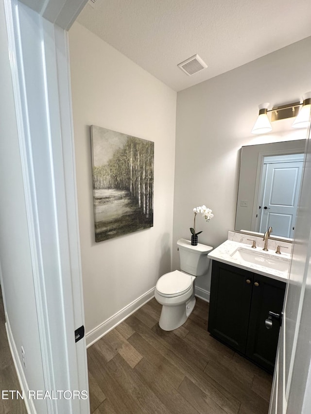 11707 Grigsby Chapel Rd, Knoxville, TN 37934 - half bath with wood finished floors, toilet, vanity, baseboards, and a textured ceiling