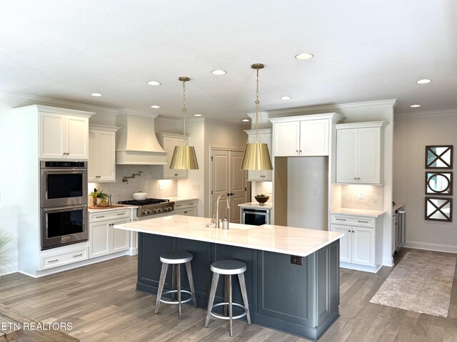 11707 Grigsby Chapel Rd, Knoxville, TN 37934 - kitchen featuring stainless steel appliances, wall chimney exhaust hood, a sink, light wood-type flooring, and decorative backsplash