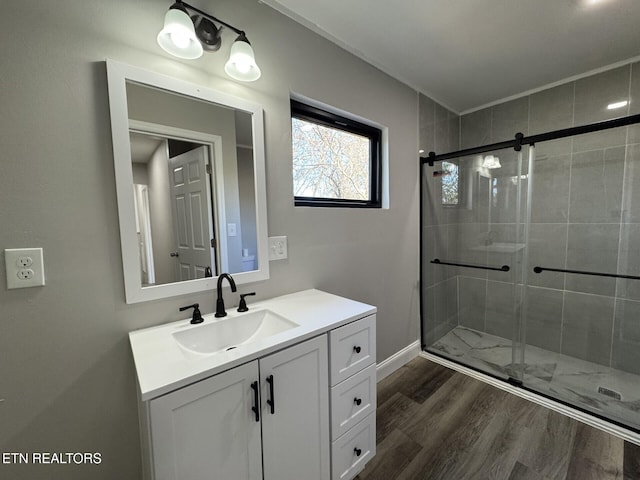 bathroom with a shower with door, vanity, and wood-type flooring