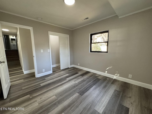 unfurnished bedroom with ornamental molding and dark hardwood / wood-style flooring