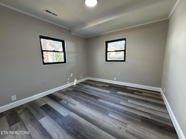 empty room with plenty of natural light, ornamental molding, and dark hardwood / wood-style floors