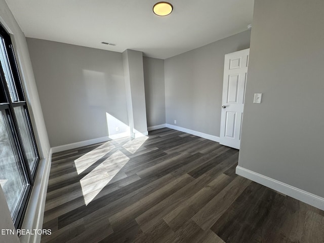 unfurnished room with dark wood-type flooring