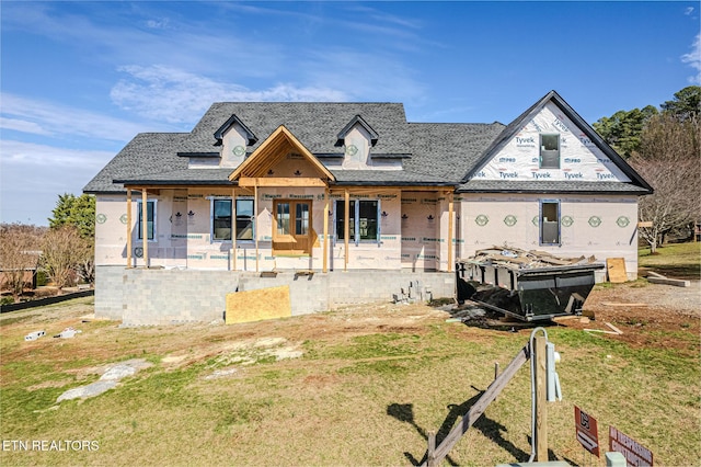 property under construction featuring covered porch and a front yard