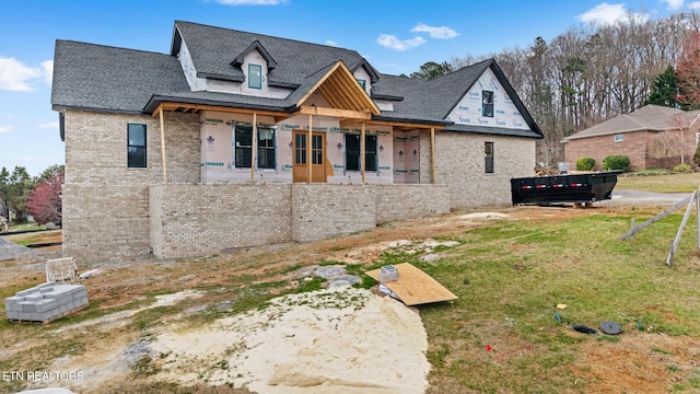 back of property with a lawn and brick siding