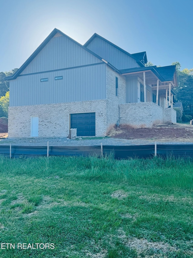 view of home's exterior featuring board and batten siding, brick siding, and a garage