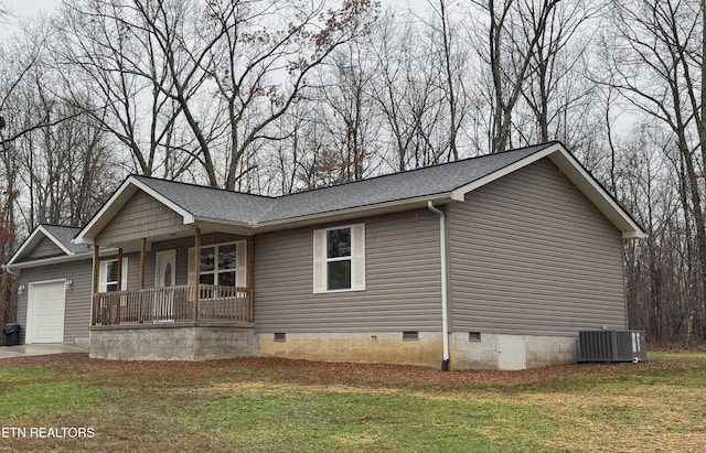 view of home's exterior with a yard, a garage, central air condition unit, and covered porch