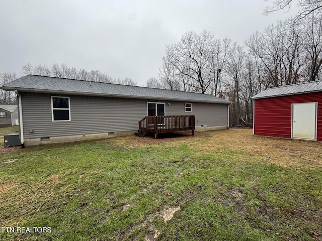 back of house with a yard, a deck, and a storage unit