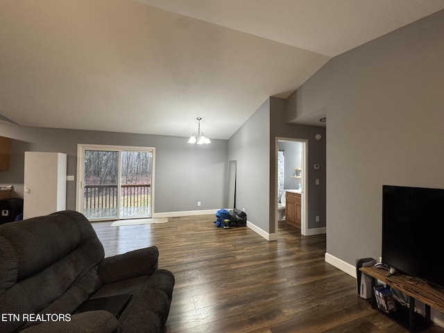 living room featuring dark hardwood / wood-style floors, vaulted ceiling, and a notable chandelier