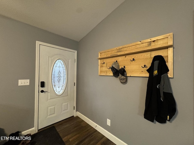 entryway with dark wood-type flooring and vaulted ceiling