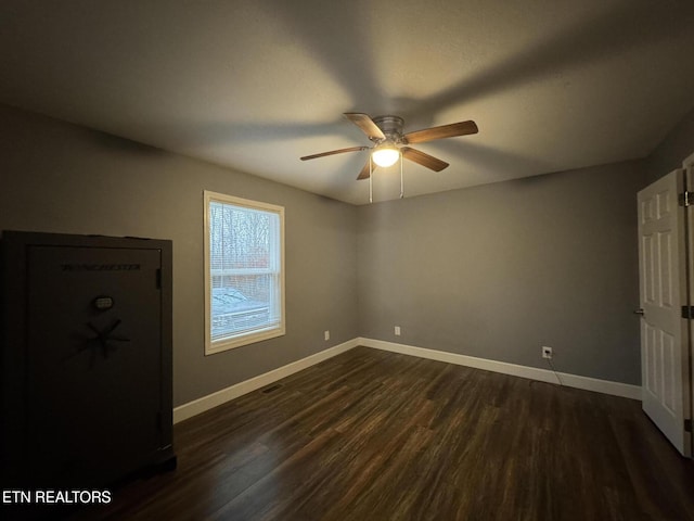 unfurnished room with dark wood-type flooring and ceiling fan