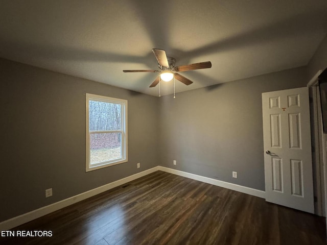 unfurnished room with dark wood-type flooring and ceiling fan