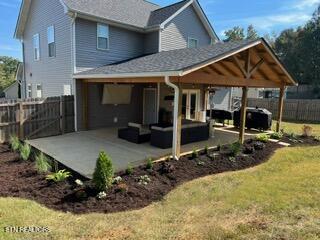 rear view of property featuring a patio area, an outdoor hangout area, and a lawn