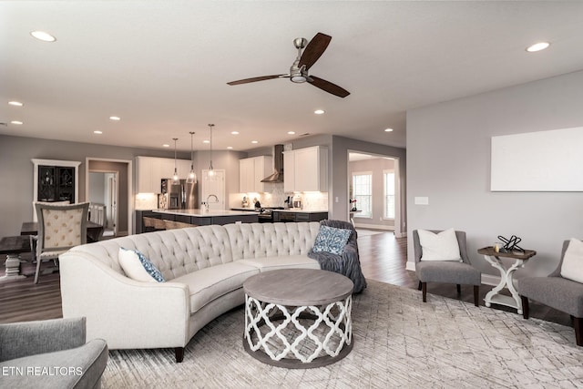 living room featuring ceiling fan and light hardwood / wood-style floors