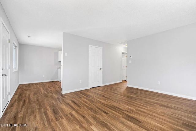 spare room with dark wood-type flooring and a textured ceiling