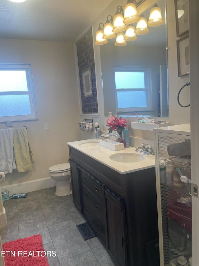 bathroom featuring toilet, a wealth of natural light, tile patterned floors, and vanity