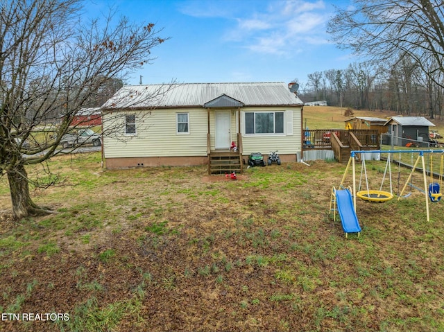 manufactured / mobile home with a trampoline, a front yard, and a playground