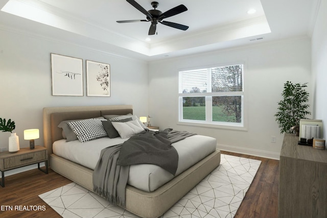 bedroom featuring light wood-type flooring, a tray ceiling, visible vents, and crown molding