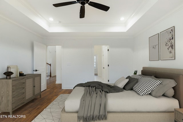 bedroom featuring light wood finished floors, a tray ceiling, and crown molding