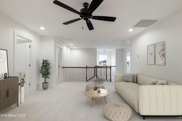 carpeted living room featuring baseboards, visible vents, and recessed lighting