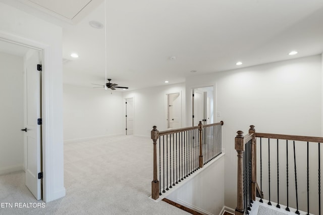 corridor with recessed lighting, attic access, light colored carpet, and an upstairs landing