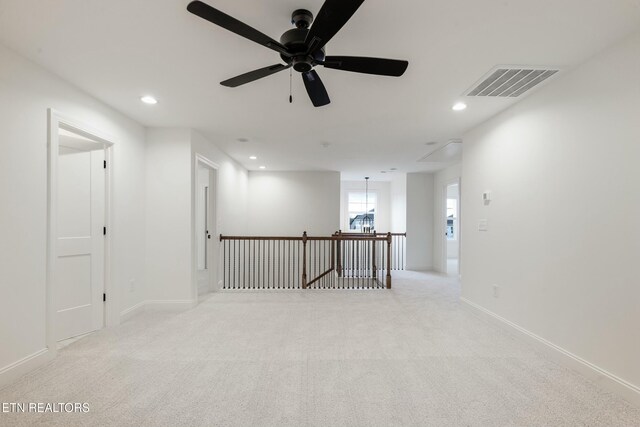 carpeted empty room featuring baseboards, visible vents, and recessed lighting