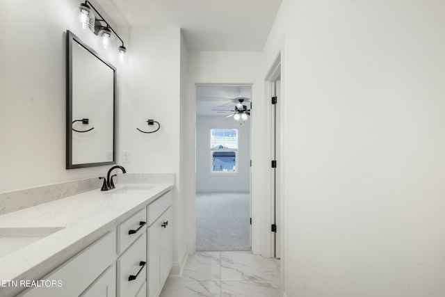 bathroom featuring marble finish floor, double vanity, and a sink