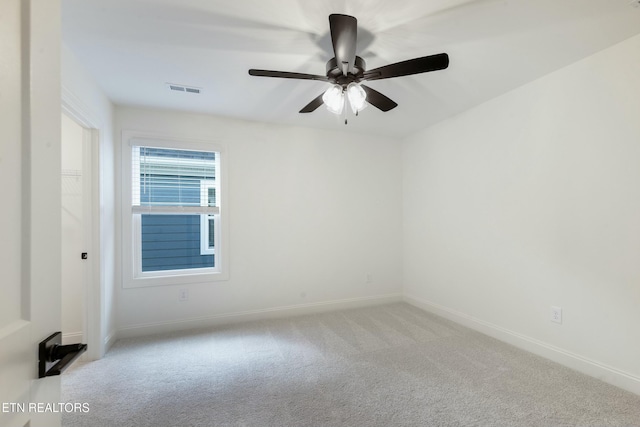 spare room featuring carpet floors, baseboards, visible vents, and ceiling fan