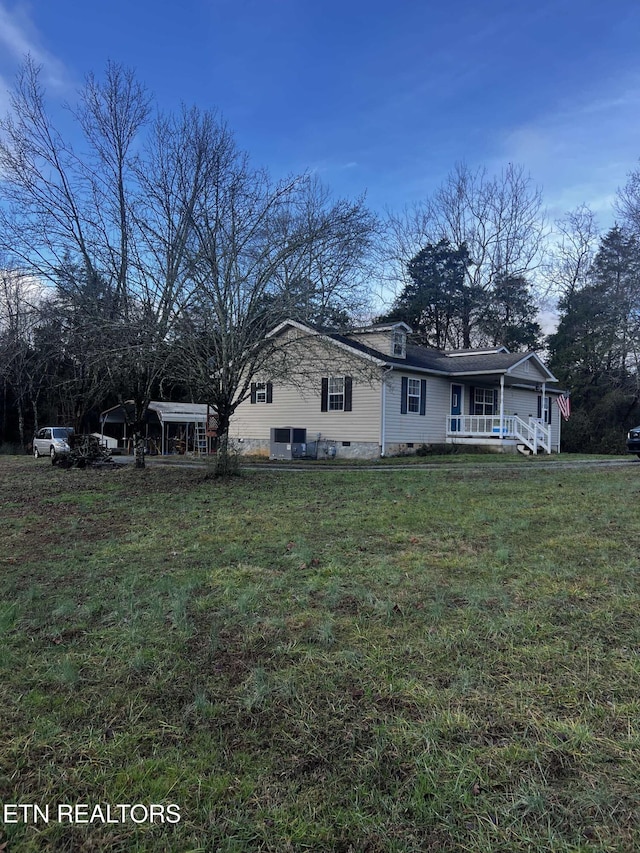 view of side of property featuring a yard and covered porch