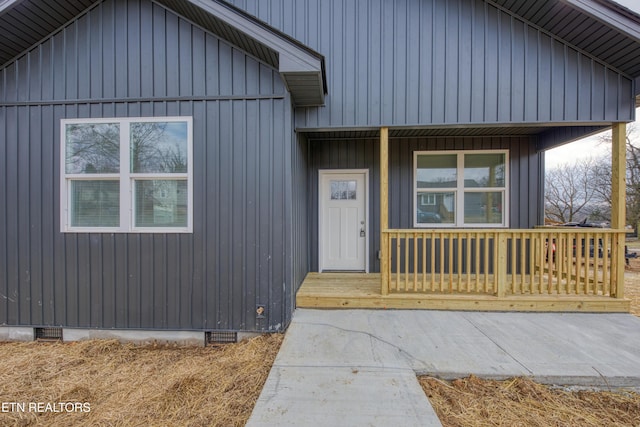 property entrance featuring board and batten siding, crawl space, and covered porch